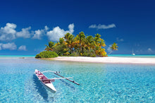 Tropical island with a small boat in clear blue water