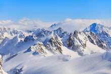 Snow-covered mountain peaks under a clear blue sky